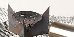 Round piece of metal sitting in a trivet 
